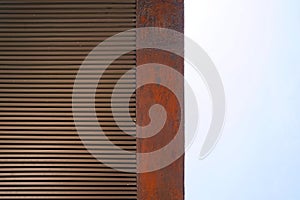 close up of old rusty metal wall with blue sky in the background.