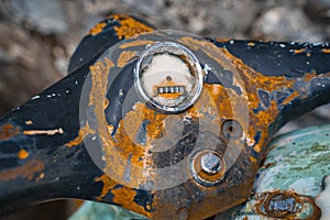 Close-up of an old rusty steering wheel of a two-wheeled motorcycle with a broken speedometer.