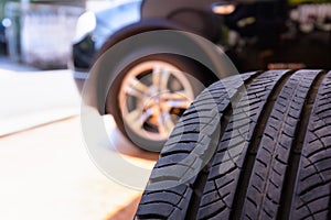 Close up of old tire with car wheel background. Tire workshop and change old wheel on the car. Used car tires stacked in piles at