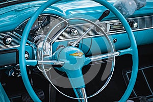 Old vintage car steering wheel and cockpit. Retro styled image of an old car radio inside classic car Chevrolet
