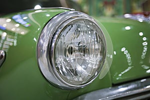 Close up old vintage green car headlight chrome