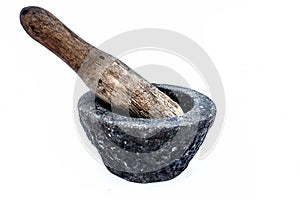 Close up of old vintage mortor and pestle isolated on white till date used in Asian and Indian homes for grinding and crushing spi