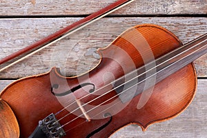 Close up old violin on wooden background.