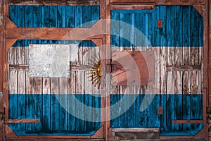 Close-up of old warehouse gate with national flag