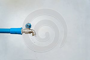 Close-up of an old water tap or faucet leaking drop of water with white background