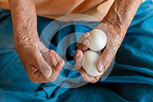 Close-up of the old woman's hand Poor Thai grandmother holds a large white duck egg for dinner.