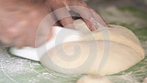 Close-up, Old Woman`s Hands Slice Plastic Knife Dough into Two Pieces