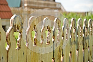 Close-up of an old yellow wooden fence. Wood fencing.