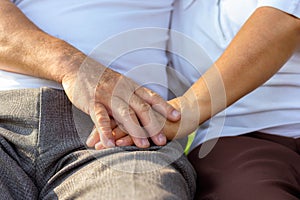 Close up older couple hands. Older husband use hand hold older wifeâ€™s hand together for encouraging his beloved wife.