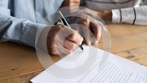 Close up older man putting signature on legal documents