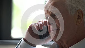Close up of older man talking on cellphone