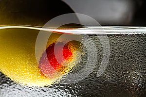 Close-up of olive with pepper in a martini glass with drops photo