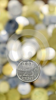 A close-up of one 25 cent coin from 1978, Netherlands. This is money. Blurred money background. Made from nickel