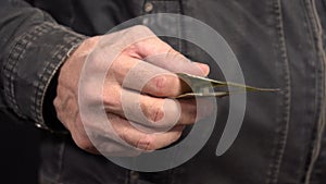 Close-up of a One Dollar in a Man's Hand in a Work Jacket. Put your Money in your Pocket