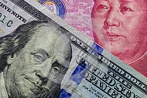 Close up of one hundred Dollar banknote over a 100 Yuan banknote with focus on portraits of Benjamin Franklin and Mao Tse-tung/USA