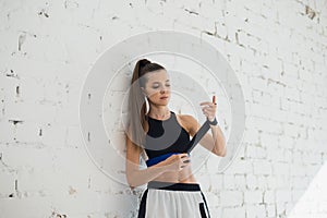 Close up of one young woman wrapping hands with black boxing wraps in gym practice boxing indoor working out fitness