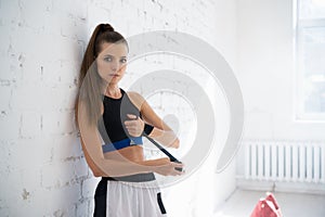 Close up of one young woman wrapping hands with black boxing wraps in gym practice boxing indoor working out fitness