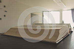 Close-up of an open book on a bookshelf in an office. Blurred background, copy space. Concept of studying, business.