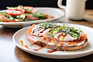 close-up of an open-face prosciutto sandwich and caprese salad