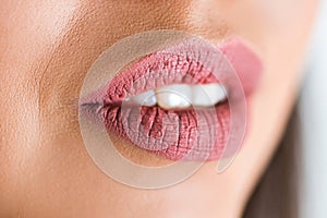 Close up of open lips of woman on white background. Pink lipstick, lip gloss on the lips.