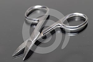 Close-up of open manicure scissors with a reflection.