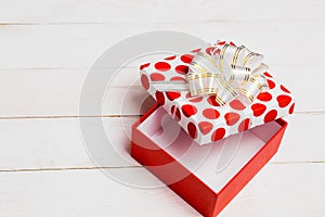 Close-up open red white gift box on wooden light table