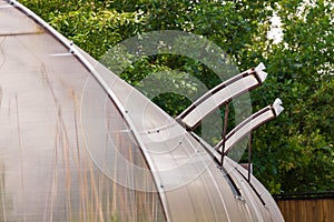 Close-up on open windows in a greenhouse constructed of polycarbonate and plastic for ventilation of hot air and the cultivation