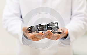 Close up of optician with glasses at optics store