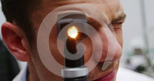 Close-up of optometrist looking through ophthalmoscope