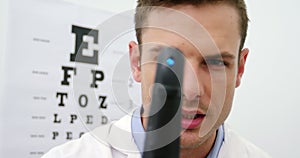 Close-up of optometrist looking through ophthalmoscope