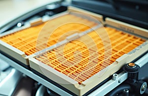 Close-up of an orange air filter installed in a vehicle engine compartment