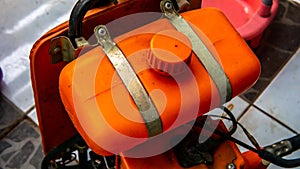 Close up of orange brush cutter machine on the floor
