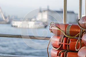 Close up of orange lifebuoy located on the ship. Blurred background. Close up