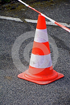 Close-up on an orange white traffic cone red-white caution