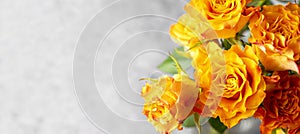 Close up orange yellow rose flowers bouquet with copy space grey background. Banner
