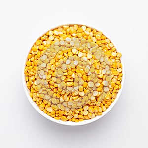 Close up of Organic Bengal Gram Cicer arietinum or split yellow chana dal on a ceramic white bowl.