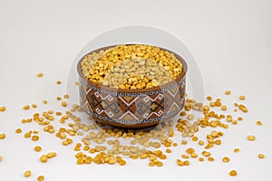 Close-up of Organic Bengal Gram Cicer arietinum or split yellow chana dal inside a  bowl. White isolated background
