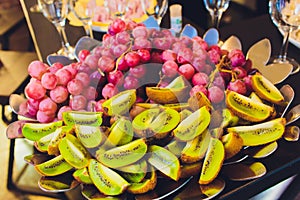 Close up of organic fresh and ripe red grapes on a luxury buffet dressed with kiwi fruit for a healthy breakfast or