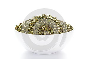 Close-up of Organic green Gram Vigna radiata or whole green moong dal inside a ceramic white bowl.