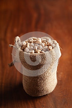Close-up of Organic small chhole chana or Kabuli chana Cicer arietinum or whole white Bengal gram dal in a standing jute bag