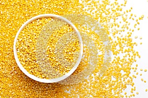 Close up of Organic yellow Gram Vigna radiata or split yellow moong dal on a ceramic white bowl with the gradient background of