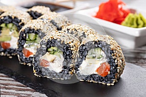 Close up of original unconventional sushi with black rice and covered with white sesame seeds.