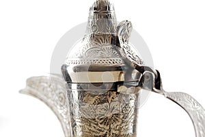 A close up of an ornate dallah, the metal pot for making Arabic coffee
