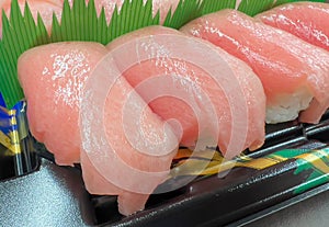 Close up of Otoro sushi on black plastic plate, ready to eat from Japanese supermarket. Otoro is part of tuna fatty belly