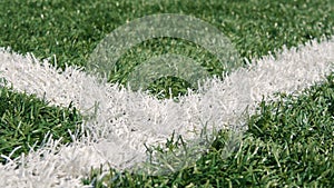 Close up of the out of bounds line on a turf football field.