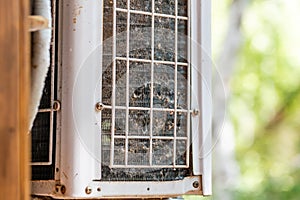 Close-up outdoor air condition unit with clogged obstructed compressor radiator grill. Details of air conditioner needed