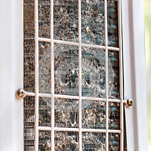 Close-up outdoor air condition unit with clogged obstructed compressor radiator grill. Details of air conditioner needed to clean