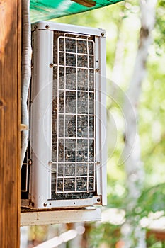 Close-up outdoor air condition unit with clogged obstructed compressor radiator grill. Details of air conditioner needed photo