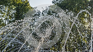 Close-up outdoor view of a public fountain with many small water jets. Public park background.