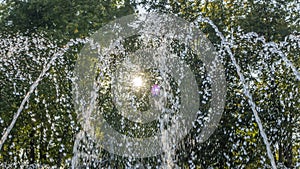 Close-up outdoor view of a public fountain with many small water jets. Public park background